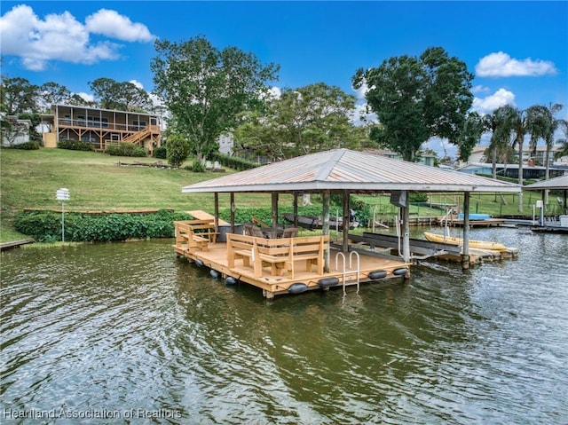 view of dock featuring a water view, a lawn, and boat lift