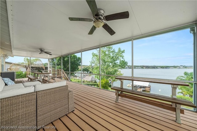 unfurnished sunroom featuring a water view and a ceiling fan