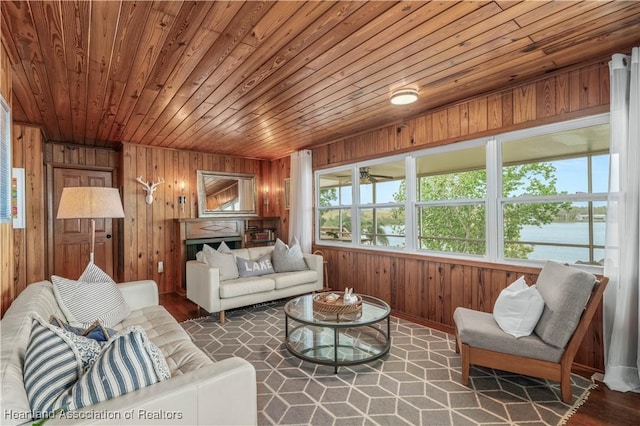 living room featuring wood walls, wooden ceiling, wood finished floors, and a water view