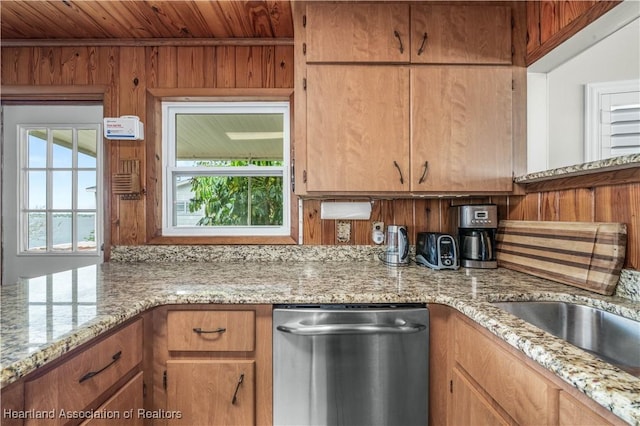 kitchen with stainless steel dishwasher, wood walls, wood ceiling, and light stone countertops