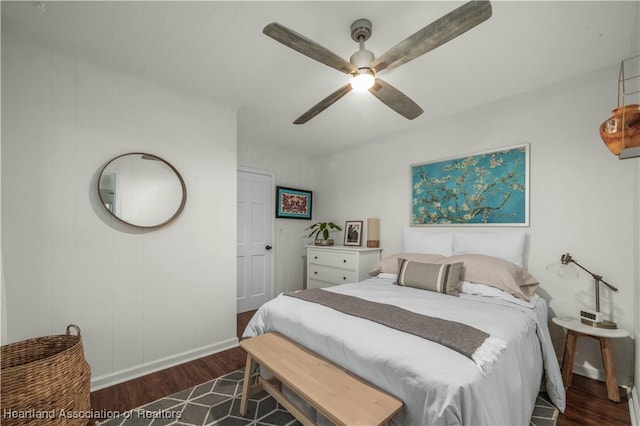 bedroom featuring wood finished floors, a ceiling fan, and baseboards