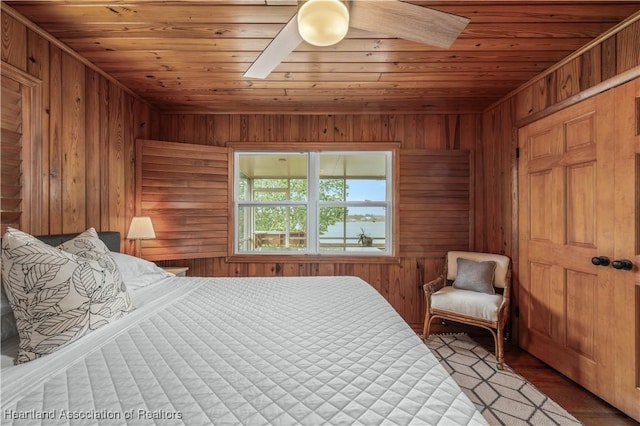 bedroom with wooden ceiling, ceiling fan, wooden walls, and wood finished floors