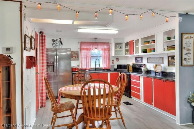 119 Mini Rd, Sebring, FL 33870 - kitchen with appliances with stainless steel finishes, red cabinetry, dark countertops, open shelves, and light wood-style flooring