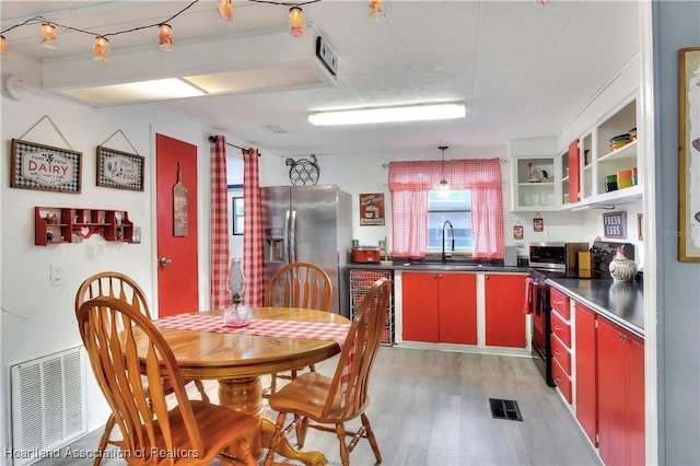 119 Mini Rd, Sebring, FL 33870 - kitchen featuring red cabinetry, stainless steel appliances, light wood-style flooring, stainless steel countertops, and open shelves