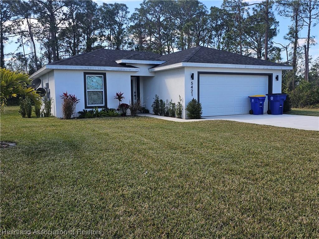 ranch-style home with a garage and a front yard