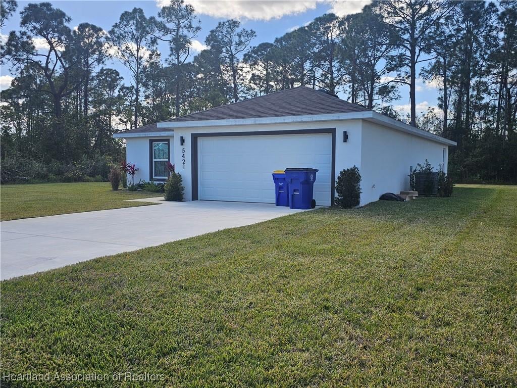 view of property exterior with a garage and a lawn