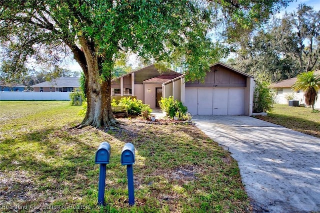 ranch-style house featuring a garage and a front lawn