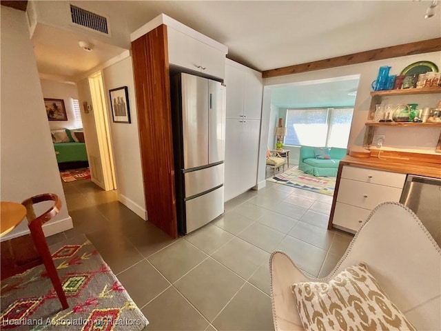 510 Lake June Rd, Lake Placid, FL 33852 - kitchen featuring white cabinets, refrigerator, and light tile patterned flooring