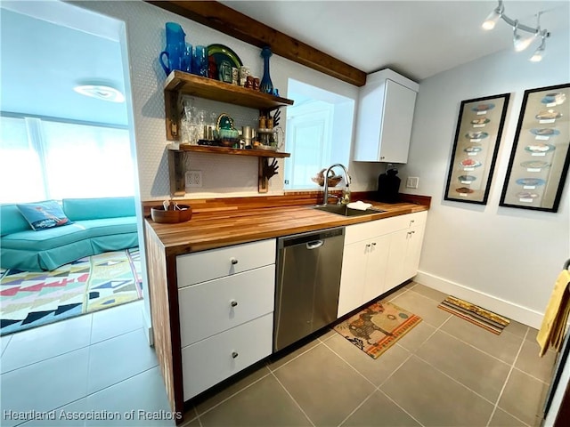 510 Lake June Rd, Lake Placid, FL 33852 - kitchen with white cabinets, sink, stainless steel dishwasher, dark tile patterned floors, and butcher block countertops