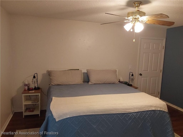 bedroom with baseboards, a textured ceiling, wood finished floors, and a ceiling fan