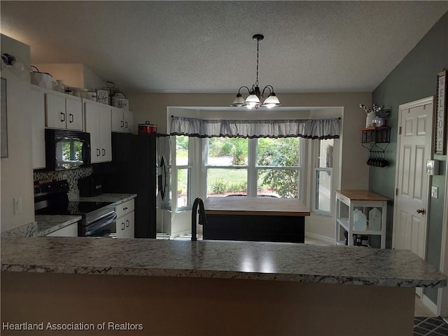 kitchen featuring light countertops, a sink, black appliances, and lofted ceiling