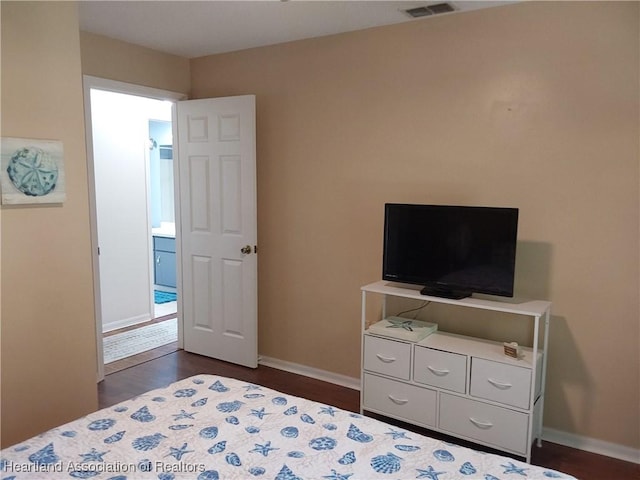 bedroom featuring baseboards, visible vents, and dark wood finished floors