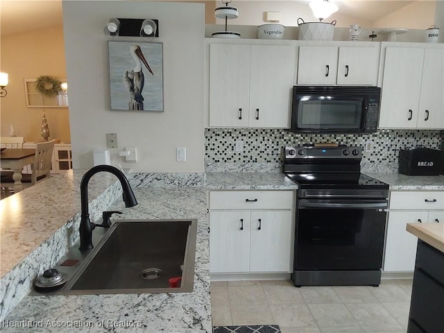 kitchen with backsplash, white cabinets, a sink, and black appliances