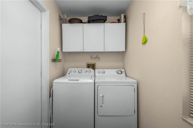 laundry room featuring washer and dryer and cabinets