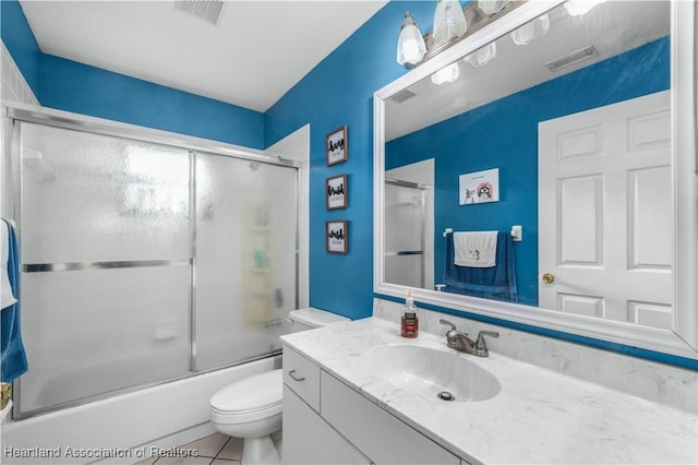 full bathroom featuring tile patterned flooring, vanity, shower / bath combination with glass door, and toilet