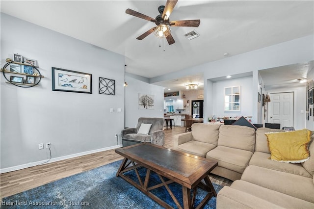 living room with hardwood / wood-style floors and ceiling fan