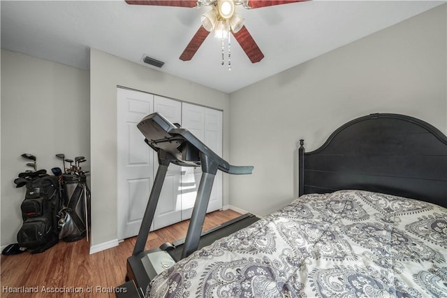 bedroom featuring hardwood / wood-style flooring, ceiling fan, and a closet