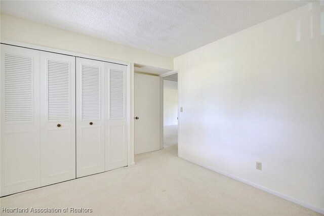 5544 Matanzas Dr, Sebring, FL 33872 - unfurnished bedroom featuring carpet floors, a closet, and a textured ceiling