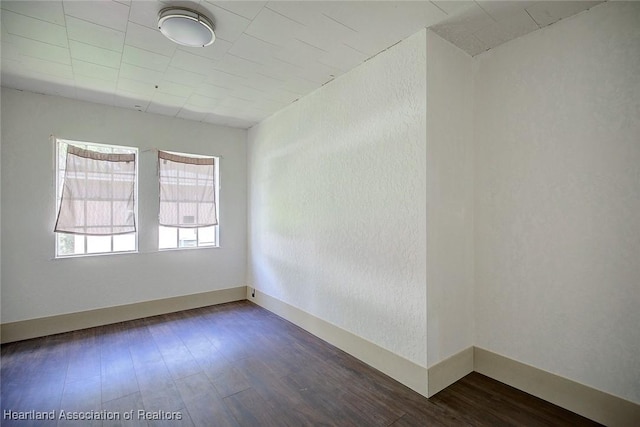 spare room featuring dark hardwood / wood-style flooring