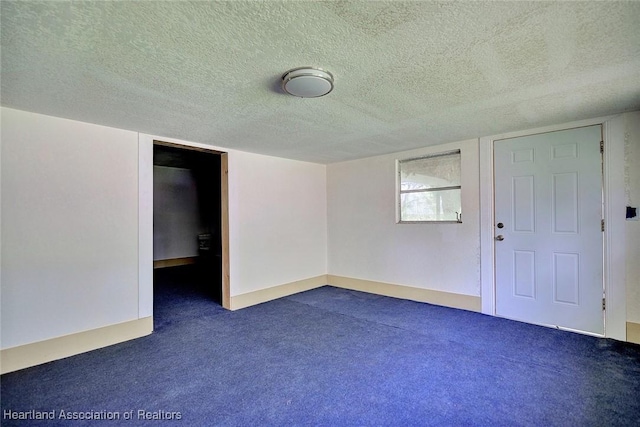 carpeted spare room featuring a textured ceiling