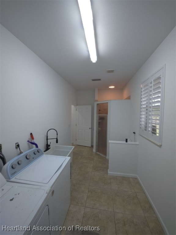 laundry area featuring visible vents, a sink, separate washer and dryer, laundry area, and baseboards