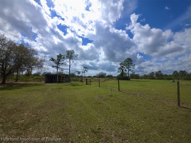 view of yard featuring a rural view and an outdoor structure