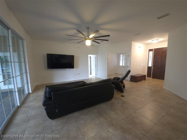 living area with tile patterned floors, visible vents, and a ceiling fan