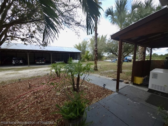 view of yard with driveway and a detached carport