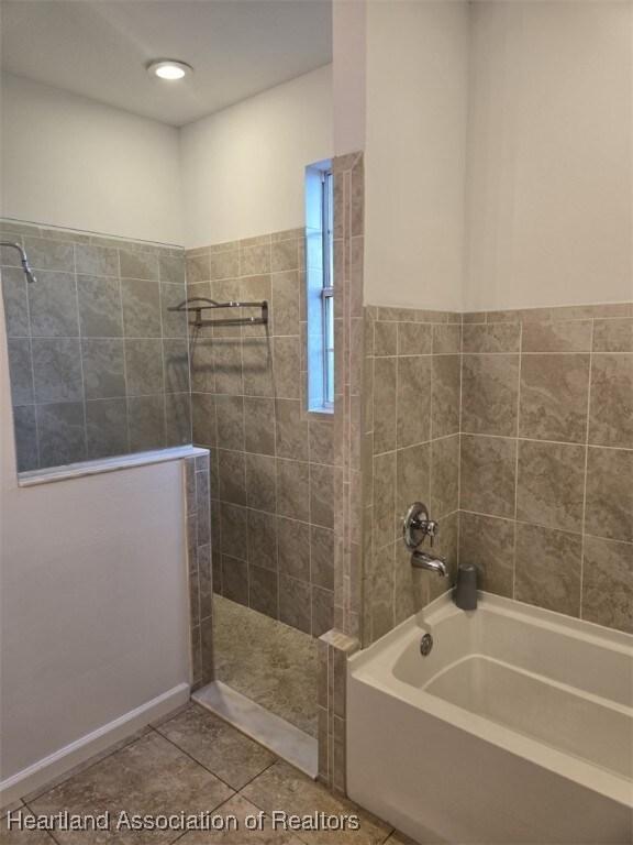 bathroom with tile patterned flooring, a bath, and a walk in shower