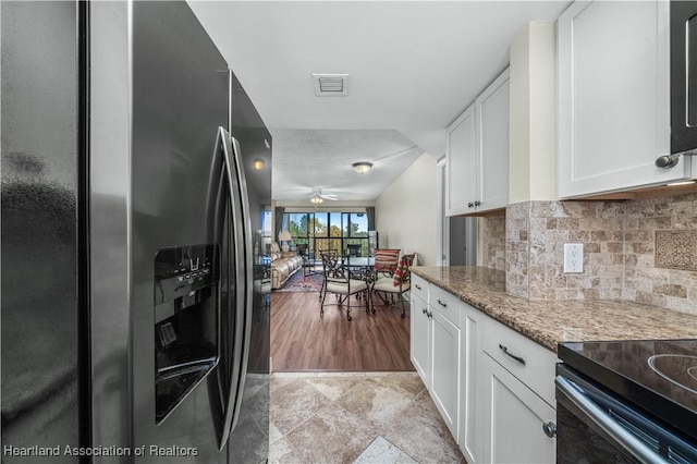 kitchen with white cabinetry, ceiling fan, light stone countertops, stainless steel fridge with ice dispenser, and decorative backsplash