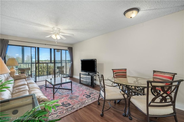 living room featuring ceiling fan, wood-type flooring, and a textured ceiling