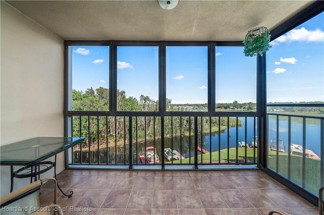 unfurnished sunroom featuring a water view