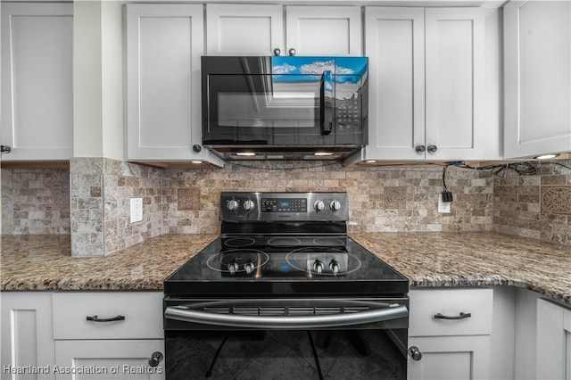 kitchen featuring decorative backsplash, white cabinetry, black appliances, and stone countertops