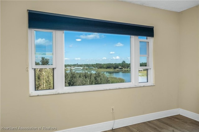 empty room featuring a water view and hardwood / wood-style flooring