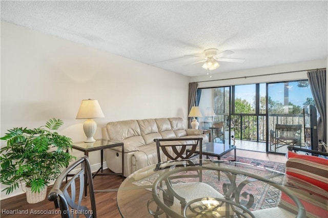 living room with ceiling fan, hardwood / wood-style floors, and a textured ceiling