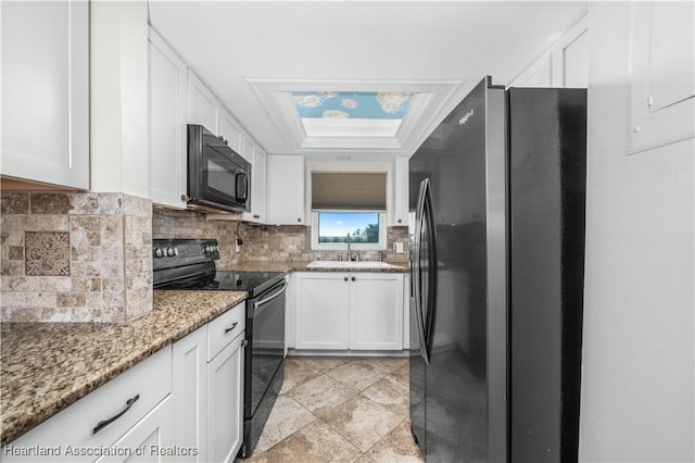 kitchen with white cabinetry, sink, light stone counters, backsplash, and black appliances