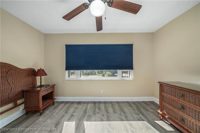 interior space with ceiling fan, light hardwood / wood-style floors, and a textured ceiling