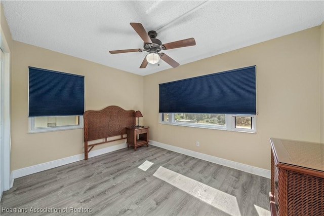 sitting room featuring ceiling fan, a textured ceiling, and light wood-type flooring