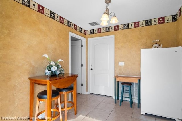 dining space featuring an inviting chandelier and light tile patterned floors