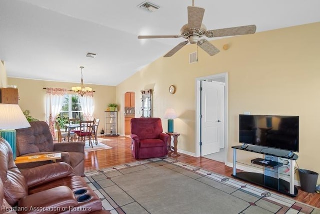 living room with vaulted ceiling, wood-type flooring, and ceiling fan with notable chandelier