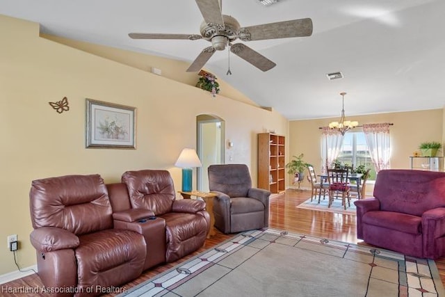 living room featuring light hardwood / wood-style flooring, ceiling fan with notable chandelier, and vaulted ceiling