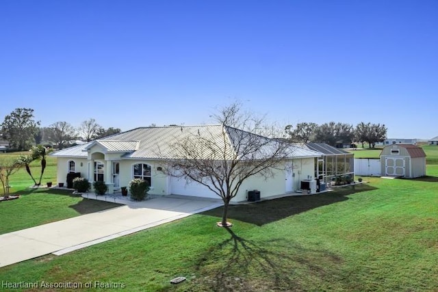 view of front of property with a lanai, a front yard, and a shed