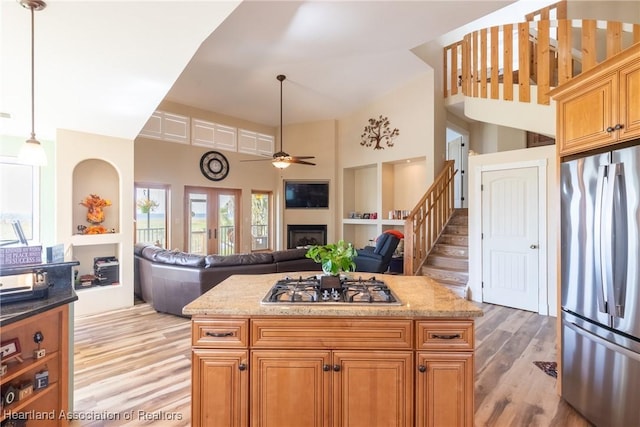 112 Wild Duck Pt, Lorida, FL 33857 - kitchen with stainless steel appliances, a fireplace, light wood-style flooring, ceiling fan, and a high ceiling