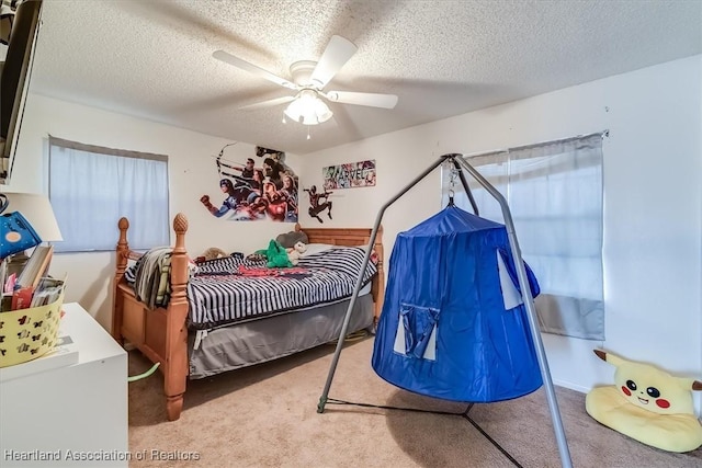 carpeted bedroom with ceiling fan and a textured ceiling