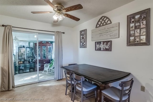 dining room featuring ceiling fan and a textured ceiling