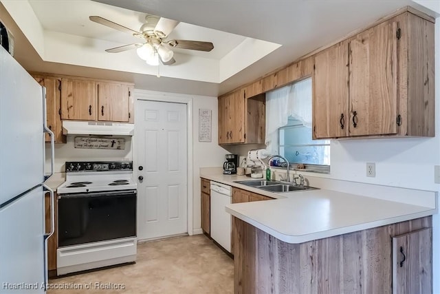 kitchen featuring ceiling fan, white appliances, a tray ceiling, and sink