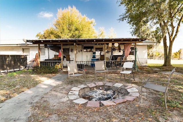 rear view of house with an outdoor fire pit and a patio