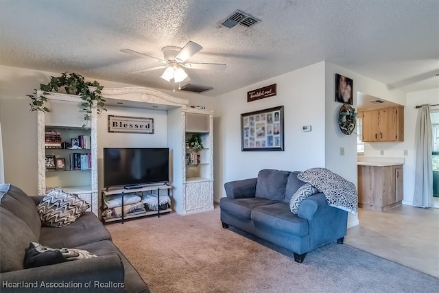 living room with ceiling fan, light carpet, and a textured ceiling