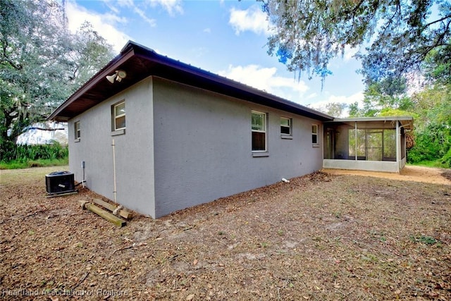 view of side of home featuring central AC and a sunroom