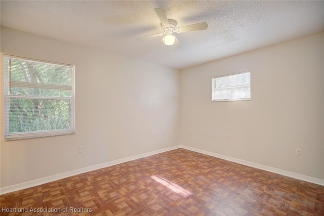 spare room featuring ceiling fan, parquet flooring, and a textured ceiling